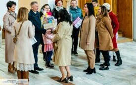 Mężczyzna wręcza podarunek kobiecie na tle konfesjonału