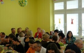 Ludzie jedzący i rozmawiający przy stole wielkanocnym