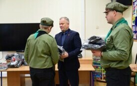 Mężczyzna przekazujący paczkę dla harcerza