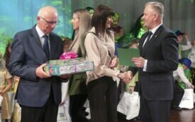 Burmistrz z radnym wręcza prezenty