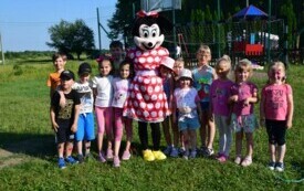 Dzieci pozują do zdjęcia z osobą przebraną za Myszkę Minnie