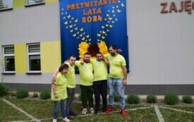 Czterech mężczyzn i kobieta obejmują się za ramiona