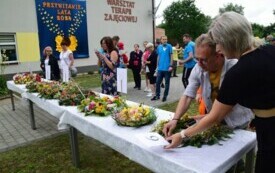 Ludzie oglądają kwiatowe wieńce