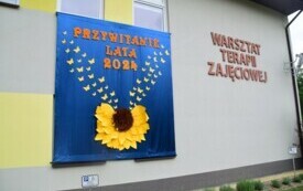 Baner ,,Przywitanie lata" na ścianie budynku WTZ