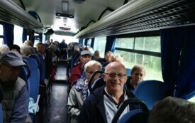 Grupa senior&oacute;w siedzi w autobusie