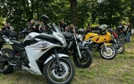 Motocykle ustawione w rzędzie, w tle grupa ludzi