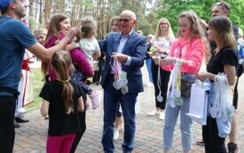 Dwie kobiety i mężczyzna wręczają medale za udział w biegu