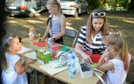 Kobieta wykonuje prace plastyczne z trzema dziewczynkami