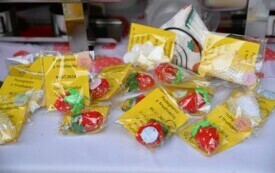 Na stole leżą breloczki w kształcie truskawek