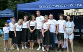 Członkowie Koła Gospodyń Wiejskich pozują do zdjęcia przy namiocie