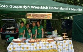 Kobiety z Koła Gospodyń Wiejskich stoją przy stole z wypiekami