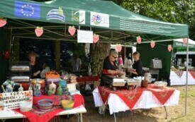 Kobiety z Koła Gospodyń Wiejskich stoją przy stołach z jedzeniem i dekoracjami