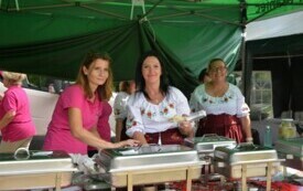 Trzy kobiety z Koła Gospodyń Wiejskich stoją przy stole z jedzeniem