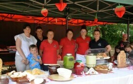 Kobiety z Koła Gospodyń Wiejskich stoją przy stole z jedzeniem