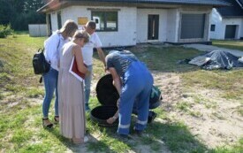 Dw&oacute;ch mężczyzn i dwie kobiety przy pompowni ściek&oacute;w