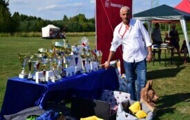 Mężczyna stoi przy stole z nagrodami