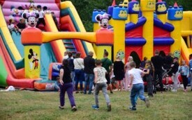 Dzieci bawią się na dmuchanych zjeżdżalniach