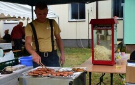 Mężczyzna piecze kiełbasy na grillu