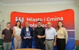 sześć os&oacute;b w tym dwi&oacute;ch mężczyzn  uściskających  sobie ręke 