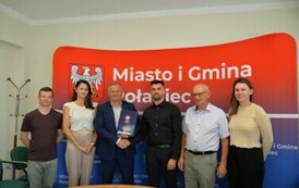 sześć os&oacute;b w tym dwie uściskające sobie ręke 