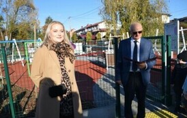 ludzie stojący i czekający na uroczyste otwarcie placu zabaw