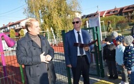 kobieta mowiąca coś do dzieci i mężczyzna stojący obok
