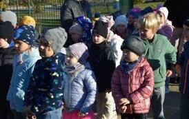 dw&oacute;jka dorosłych i dzieci stoją przed bramą