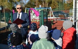 osiem dorosłych os&oacute; czeka na uroczyste otwarcie placu zabaw