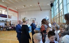 burmistrz Jacek Nowak, sekretarz Bogumiła Niespodziewana, radny Andrzej Baran wręczają upominki pierwszoklasistom