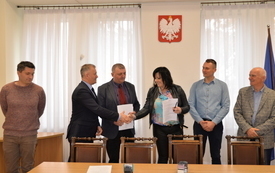 Od lewej: pracownik urzedu radosław Pluciński, burmistrz - Jacek Nowak składa gratulacje preze, zastępca burmistrza Jarosław Kądziela przekazuje umowe prezez PGK Magdalenie G&oacute;ral, kierownik - Adam Bryk, radny - Andrzej Wawrzyniec