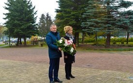 burmistrz Jacek Nowak z sekretarz Bogumiłą Niespodziewaną , burmistrz trzyma w ręce wiązankę kwiat&oacute;w z biało-czerwonych