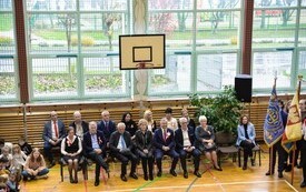zaproszeni goście, kt&oacute;rzy siedzą na krzesłach i uczestniczą w akademii, wśr&oacute;d nich burmistrz Jacek Nowak oraz sekretarz Bogumiła Niespodziewana
