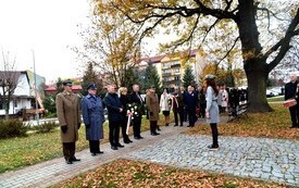 grupa ludzi, delegacji składających kwiaty, burmistrz, zastępca burmistrza, sekretarz, radni, mieszkańcy
