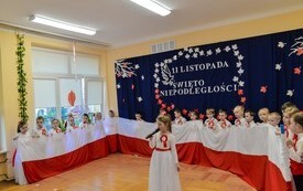grupa przedszkolak&oacute;w trzymających flagę biało czerwoną