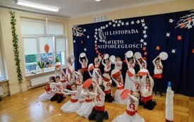 grupa przedszkolak&oacute;w trzymająca w rękach k&oacute;łka białe, czerwone i biało czerwone