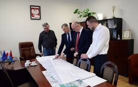 na zdjęciu czterech mężczyzn, kt&oacute;rzy analizują mapę, tereny pod inwestycję