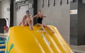 Dzieci na basenie w Połańcu na dmuchanym torze przeszk&oacute;d ustawionym w ramach ferii na sportowo