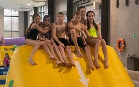 Dzieci na basenie w Połańcu na dmuchanym torze przeszk&oacute;d ustawionym w ramach ferii na sportowo