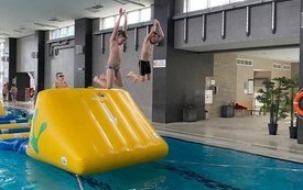 Dzieci na basenie w Połańcu na dmuchanym torze przeszk&oacute;d ustawionym w ramach ferii na sportowo
