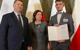 dw&oacute;ch mężczyzn, po środku kobieta, jeden trzyma dyplom