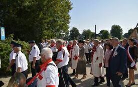 na zdjęciu barwny korow&oacute;d z uczestnikami dożynek, orkiestrą i sztandarem